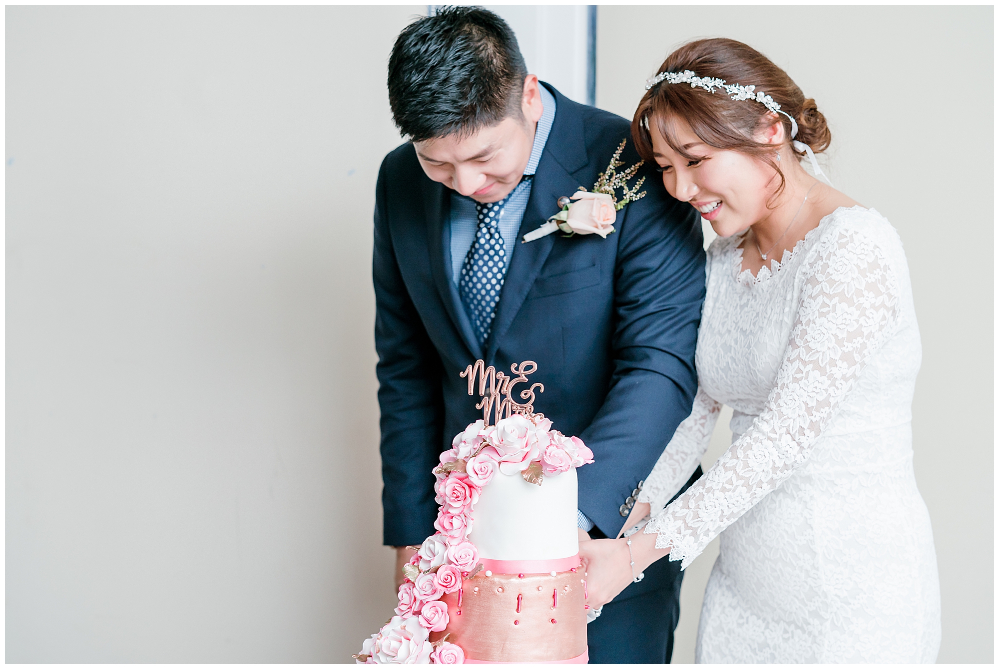 Bride and groom cutting pink and rose gold wedding cake