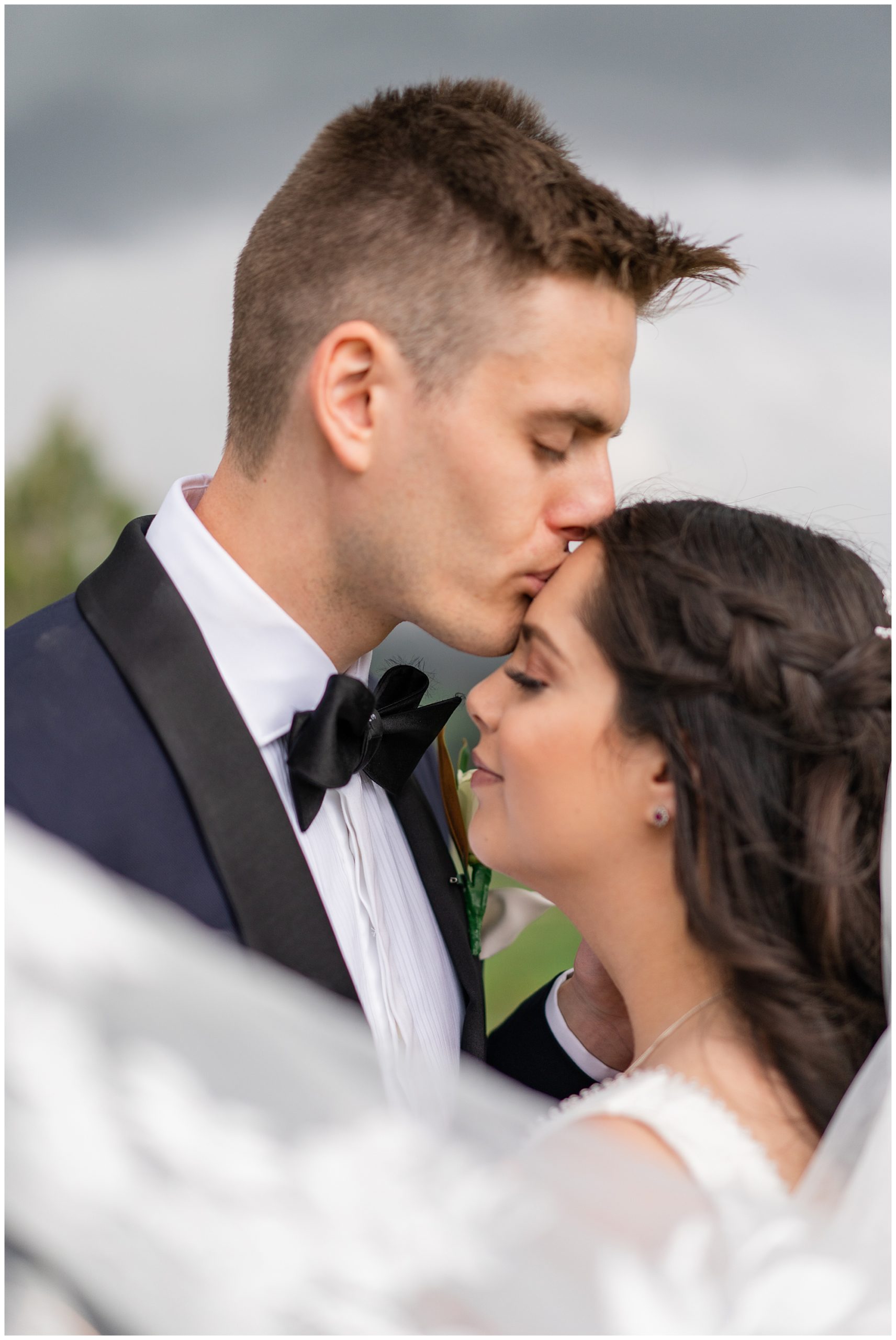 Groom kissing bride on her forehead at their wedding | Australian wedding photographer