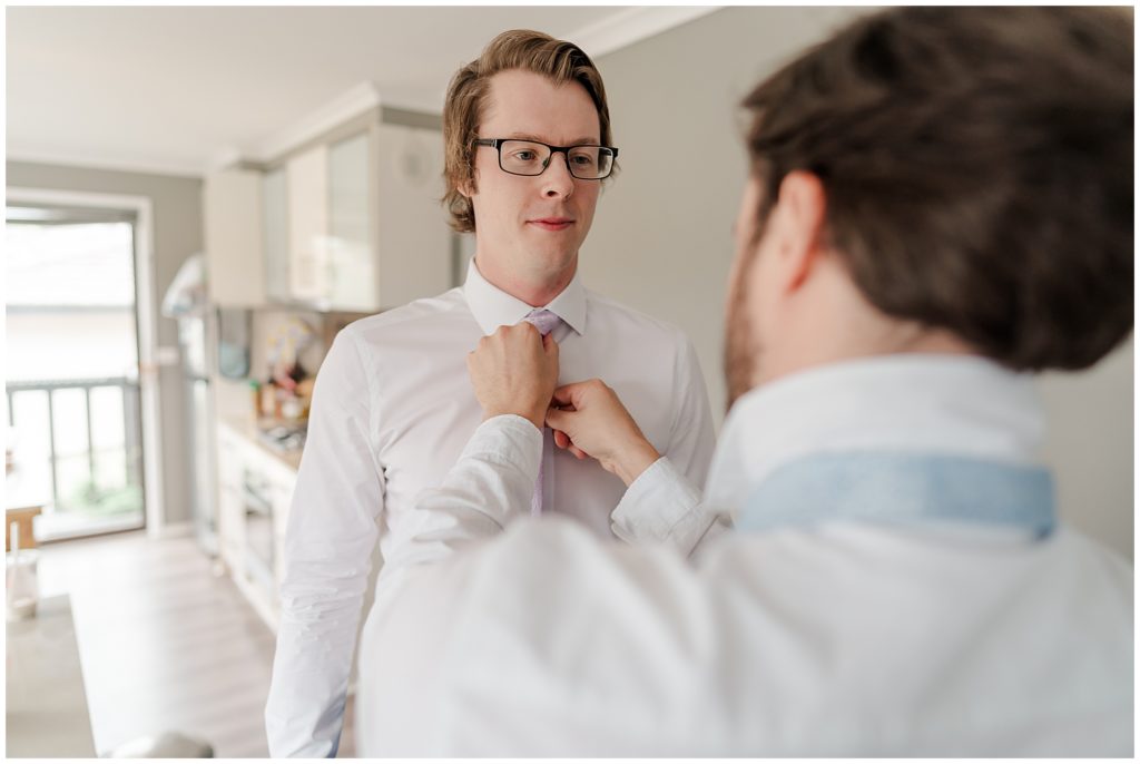 Groomsmen helping the groom with his tie| Canberra wedding photographer