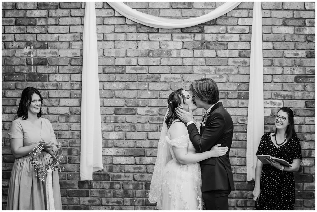 Black and white image of a couple kissing at their wedding in Canberra Local venue