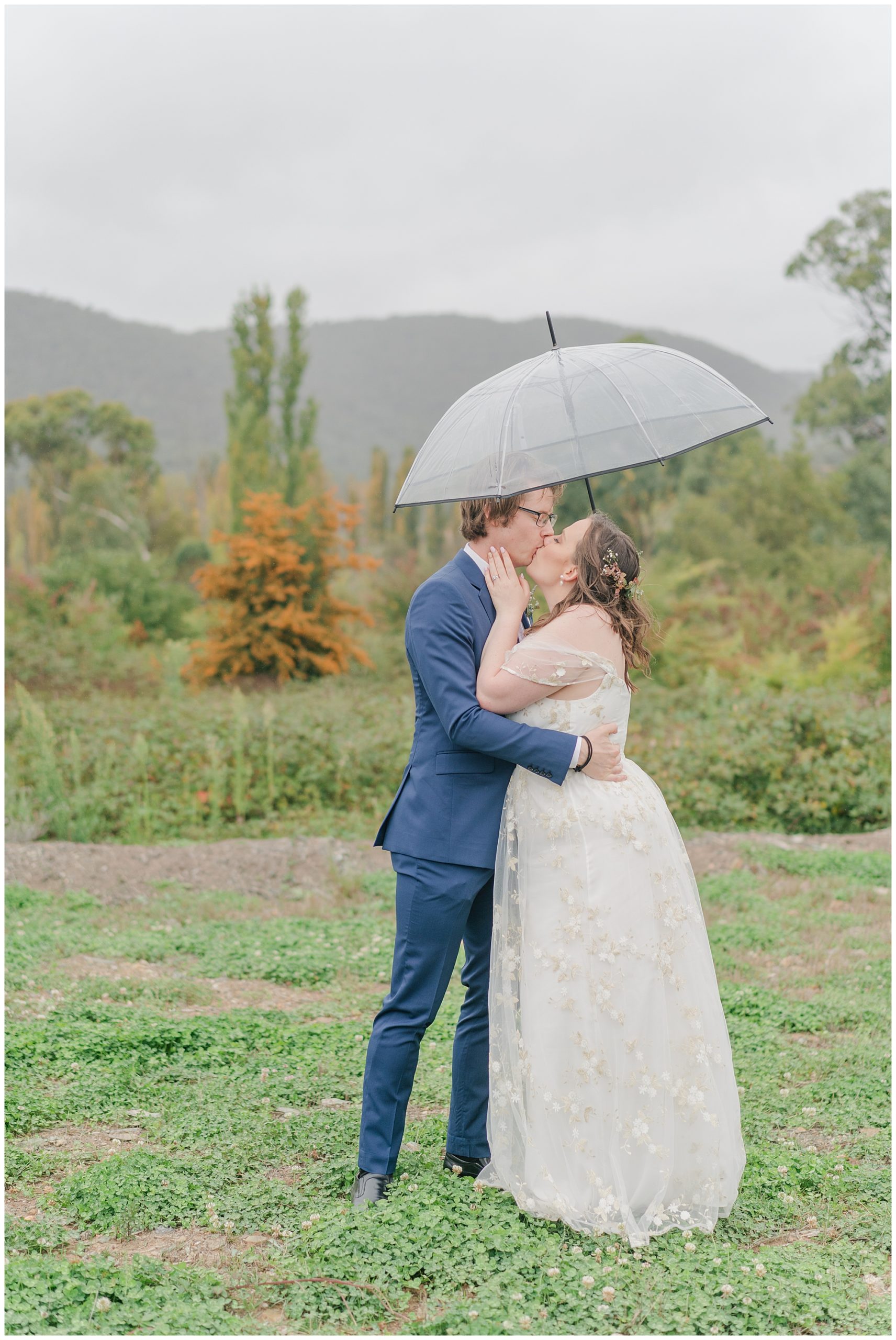 lovely bride and groom kissing in the rain on their wedding day