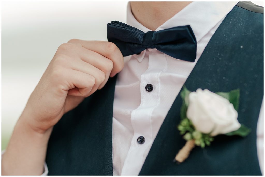 Groom tying his black tie before his wedding | Yacht Club Canberra  