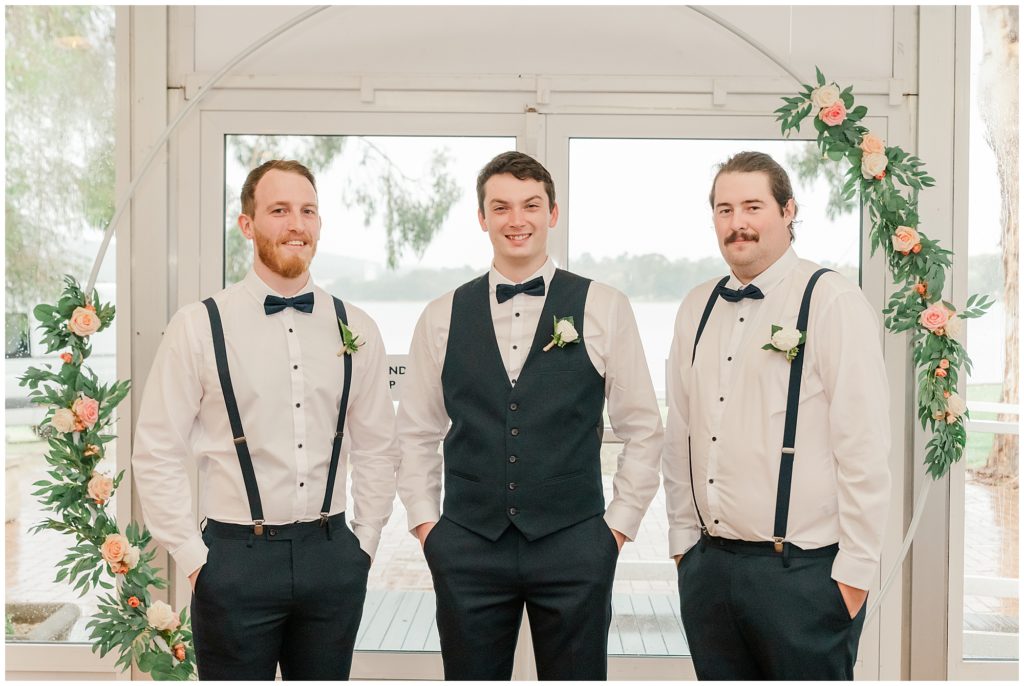 Groom and his groomsmen standing in front of the arbor at Yacht Club Canberra  