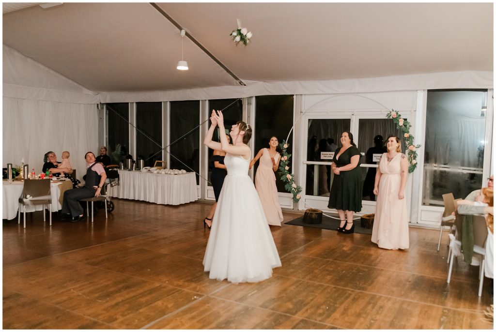 Bride throwing her bouquet at her wedding reception