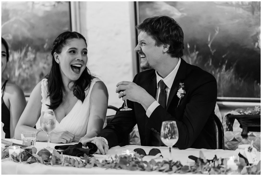 Bride and groom laughing at their speeches